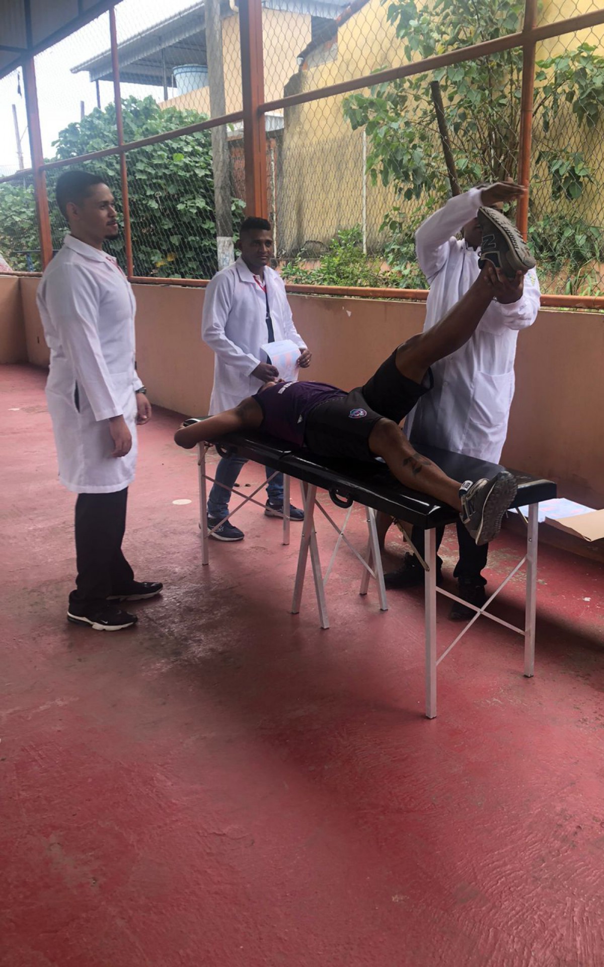 Fisioterapeuta e auxiliares  realizando teste de membros Inferiores