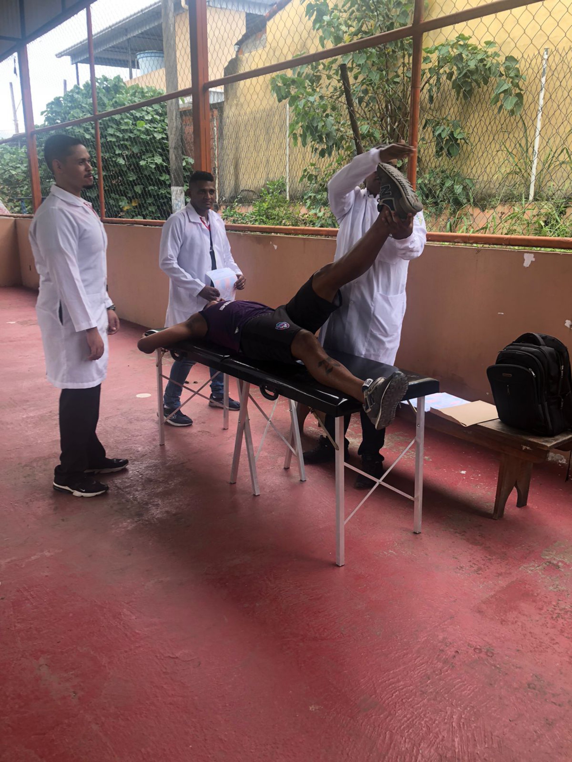 Fisioterapeuta e auxiliares  realizando teste de membros Inferiores - Divulga&ccedil;&atilde;o