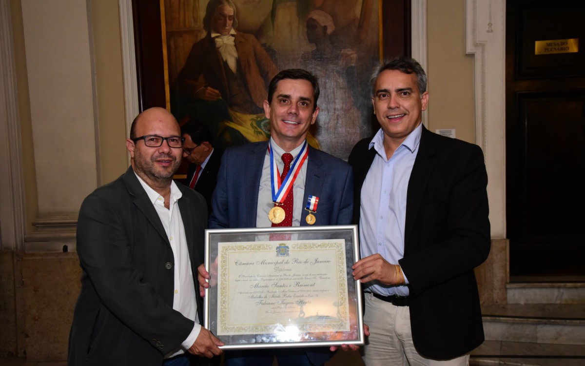 No meio, o prefeito de Maricá Fabiano Horta com as devidas honrarias, a medalha Pedro Ernesto e o certificado e ao seu lado esquerdo Olavo Noleto Presidente da CODEMAR e do lado direito o Secretário de Comunicação de Maricá Márcio Jardim - Foto Elsson Campos