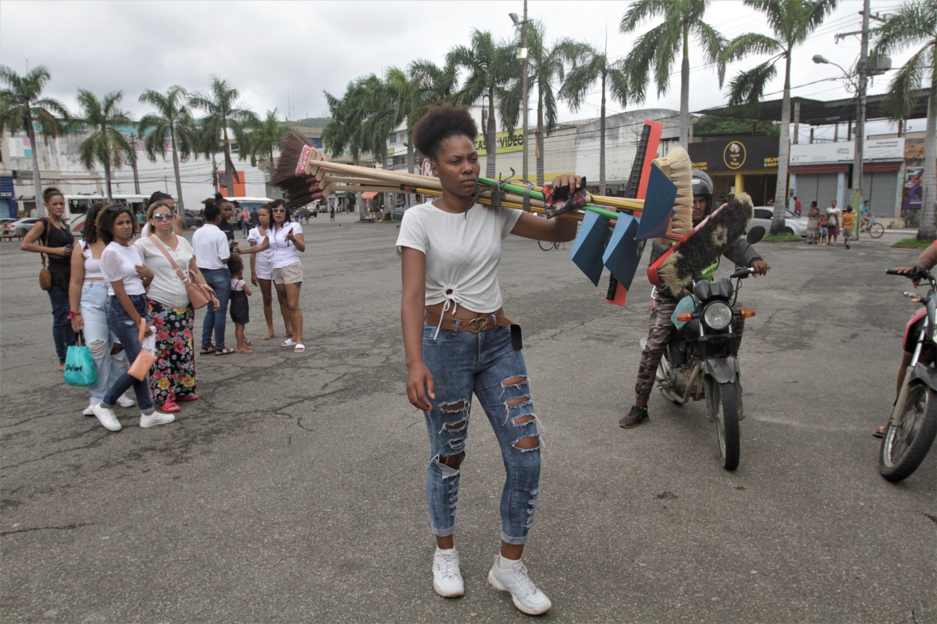 Maria Ysis Vitória, esposa de Diego, carrega facho de vassouras que estavam com seu marido no momento em que foi baleado - Marcos Porto/Agencia O Dia