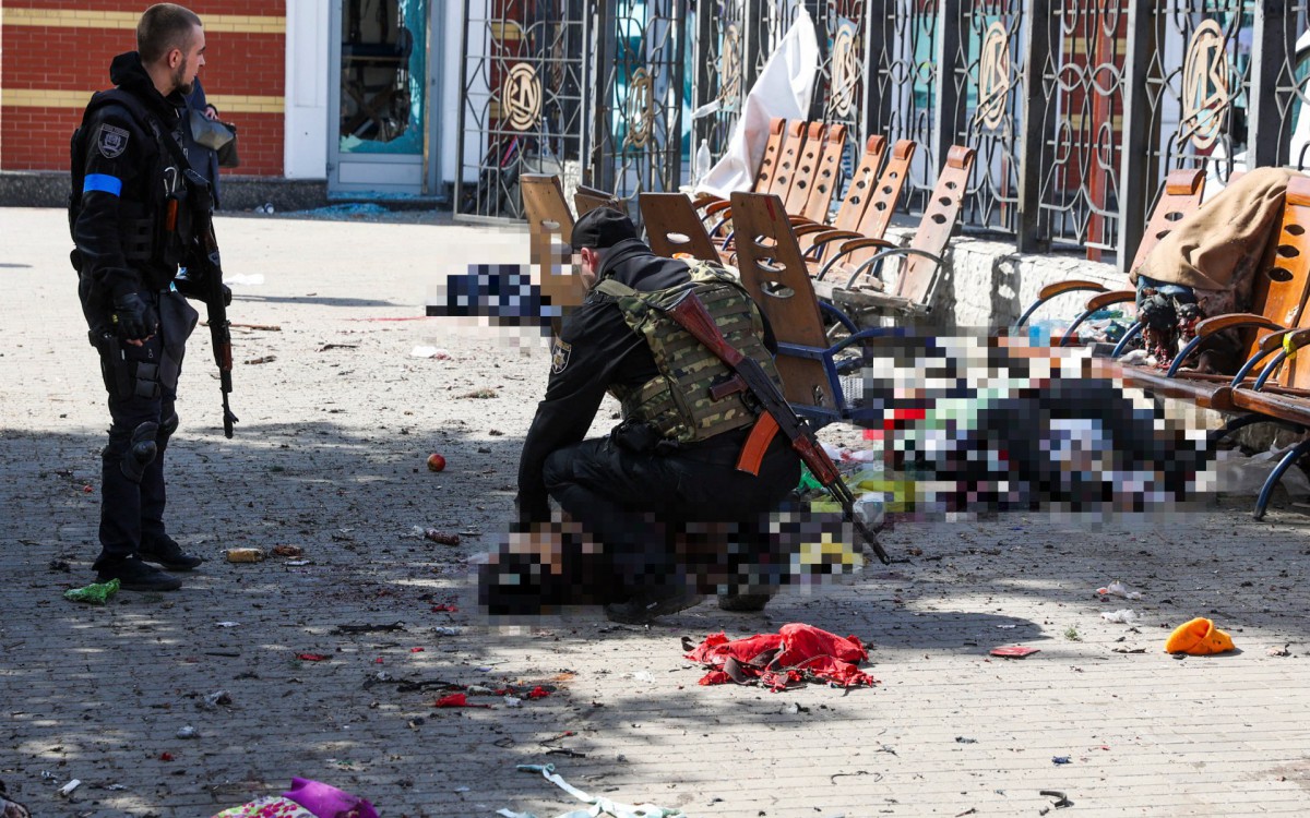 Policiais checam sinais vitais de vítima em estação de trem, na Ucrânia - Anatolii STEPANOV / AFP