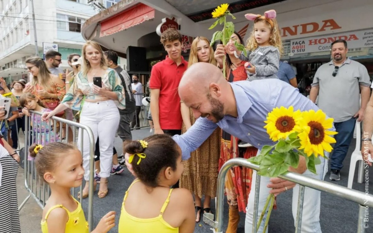 Prefeito Vinicius Claussen recebe flores de crian&ccedil;as durante desfile de P&aacute;scoa, no &uacute;ltimo domingo