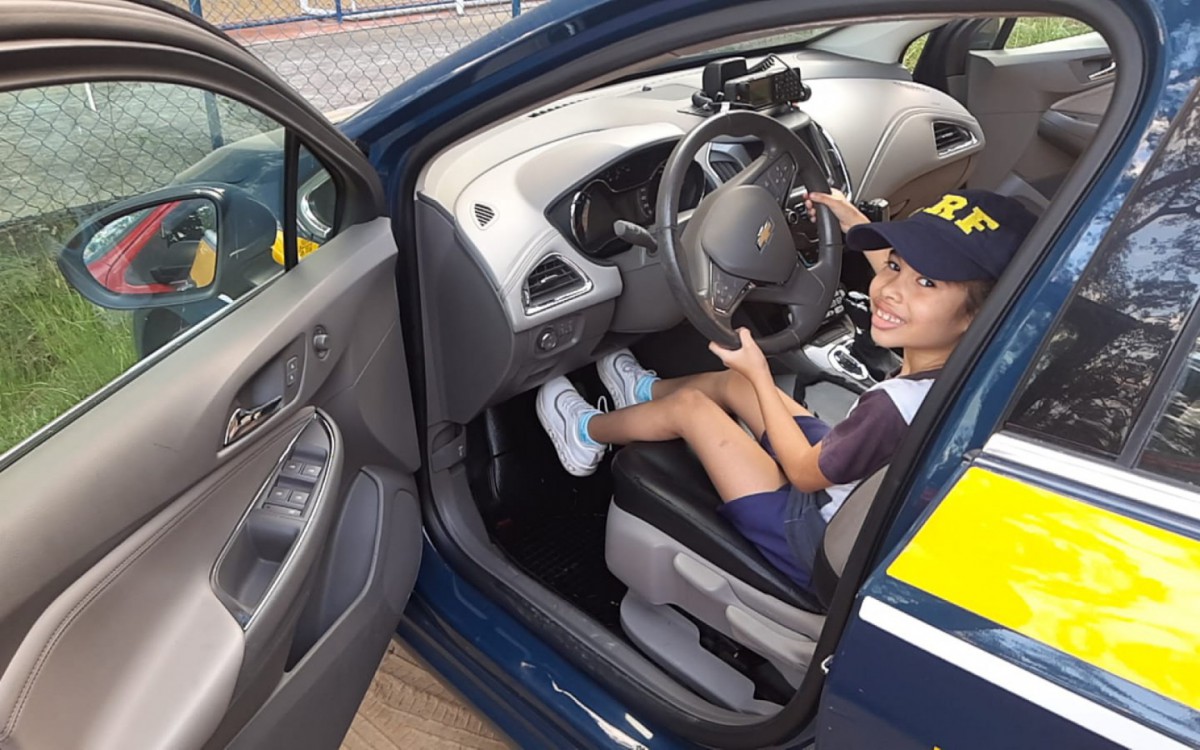 Menina tamb&eacute;m conheceu uma viatura da PRF, com direito a acionar a sirene.
