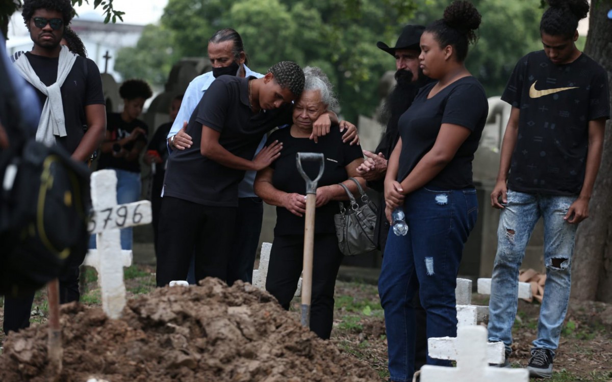Mãe de cabeleireira morta é abraçada pelo neto durante sepultamento no cemitério do Caju, na Zona Portuária - Cleber Mendes/Agência O Dia