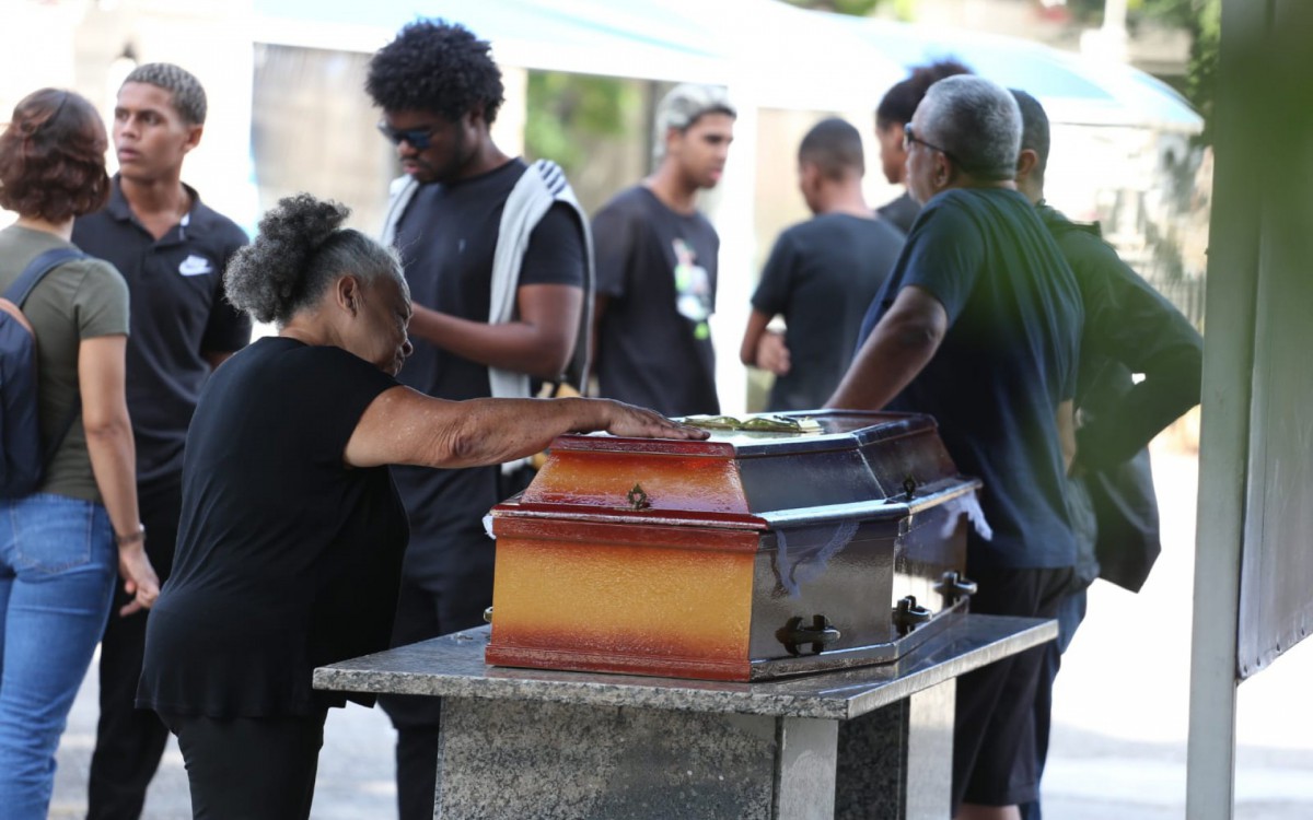 Dona Divone Ferreira da Cunha, de 72 anos, se despede da filha durante sepultamento