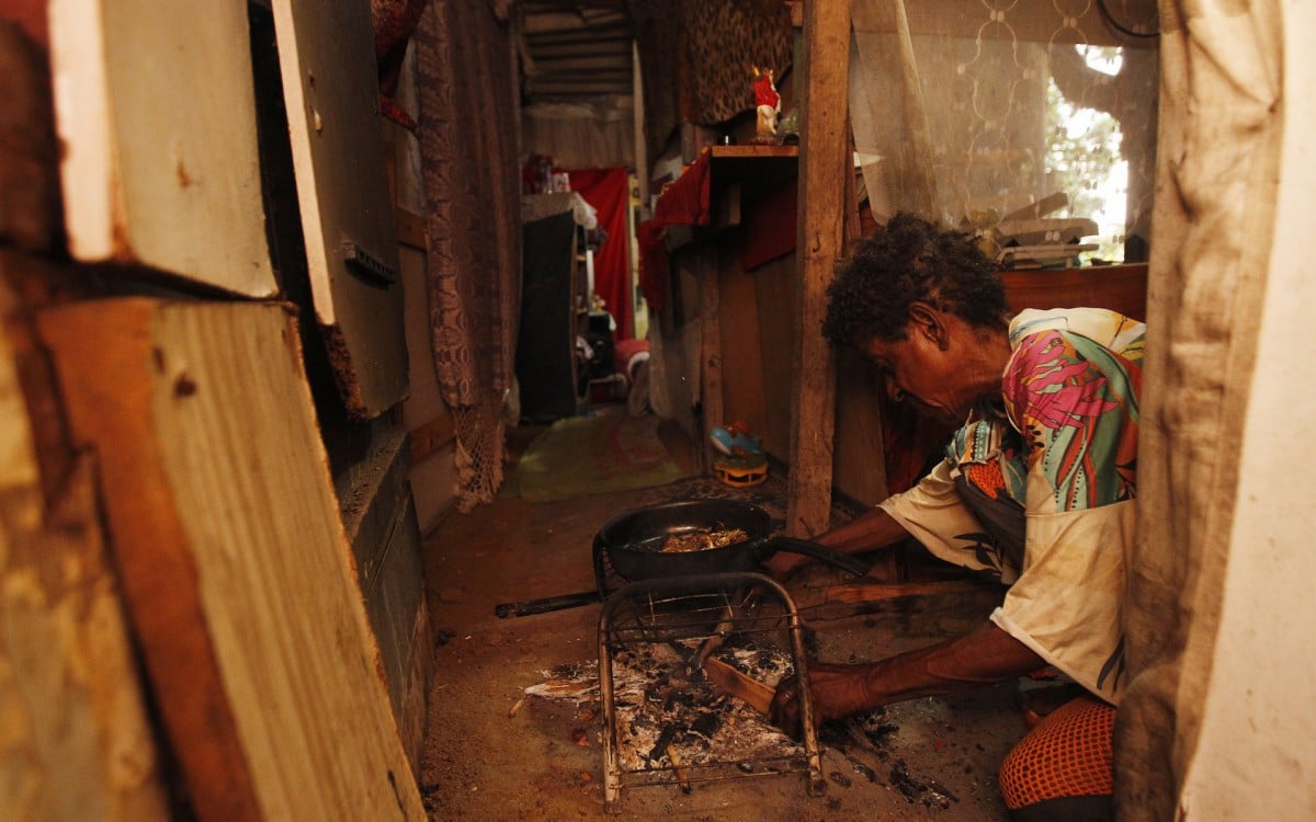 Maria Eunice Guimarães, 64 anos, cozinha em fogão improvisado dentro de sua casa, no Vietnã do Pavão-Pavãozinho - Reginaldo Pimenta / Agencia O Dia