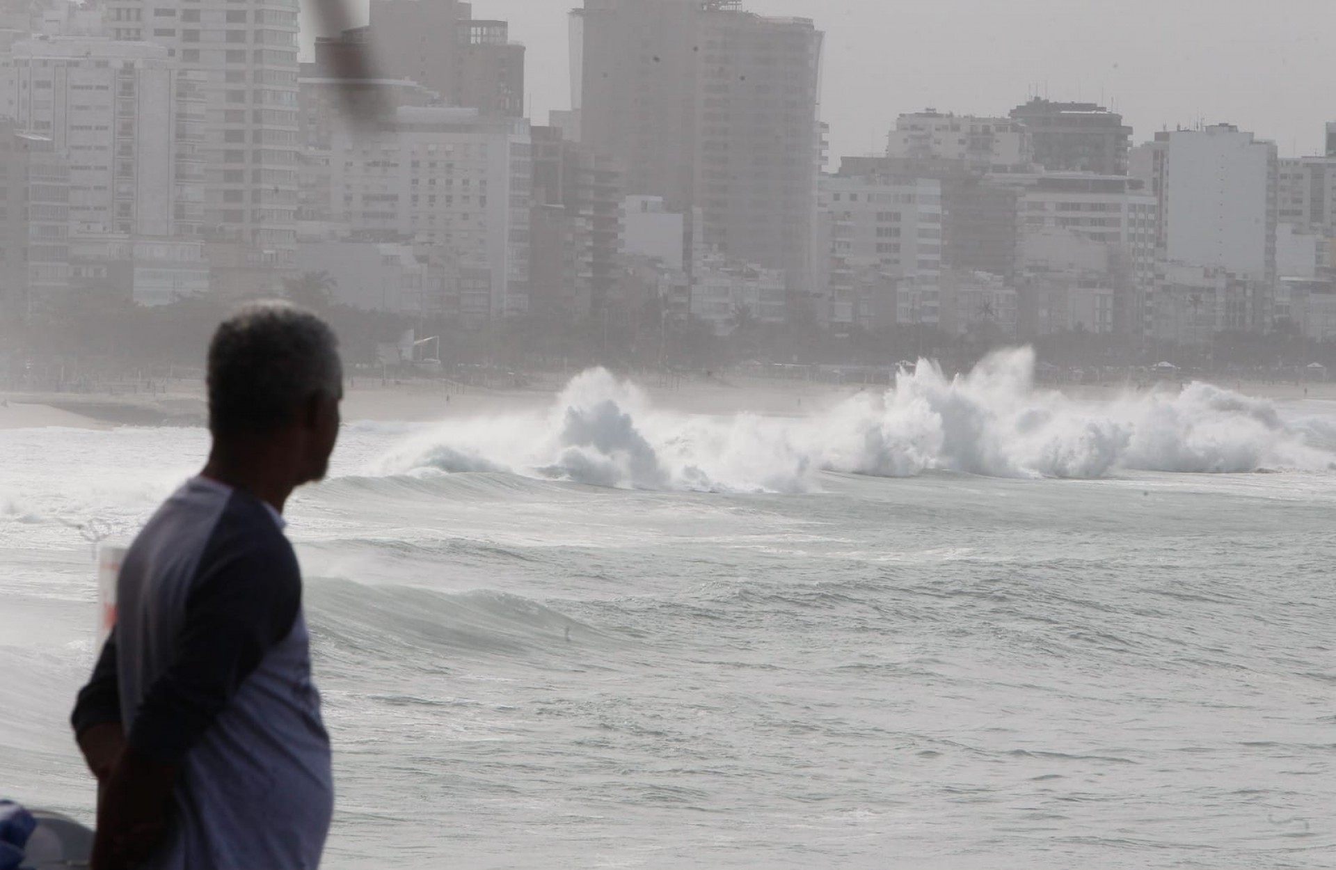 Pedestre observando mar de ressaca na praia do Leblon, na Zona Sul - Reginaldo Pimenta/Ag&ecirc;ncia O DIA