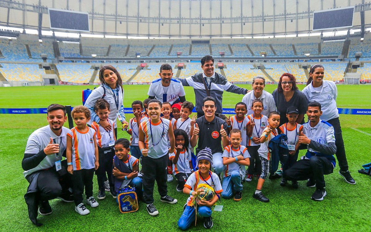 Alunos da creche, recreadores e guias do projeto Passeio do Bem no gramado do maracan&atilde;