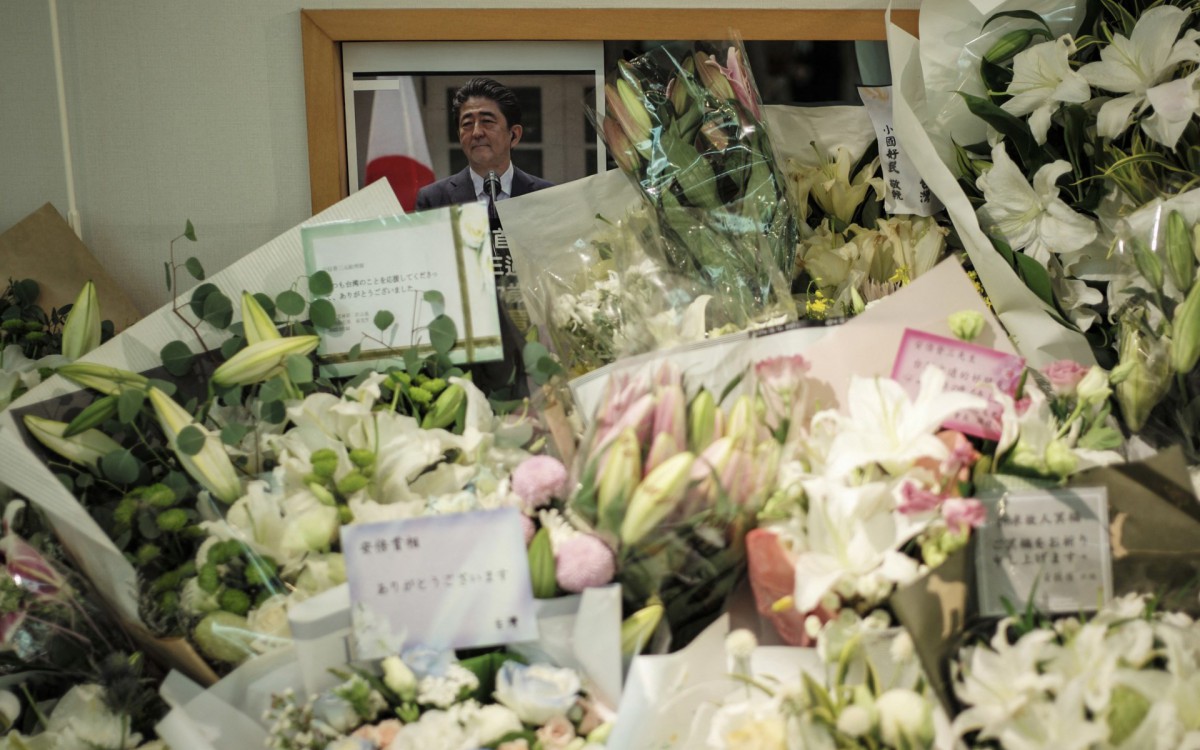 Pessoas deixam flores em homenagem ao ex-premiê - SAM YEH / AFP
