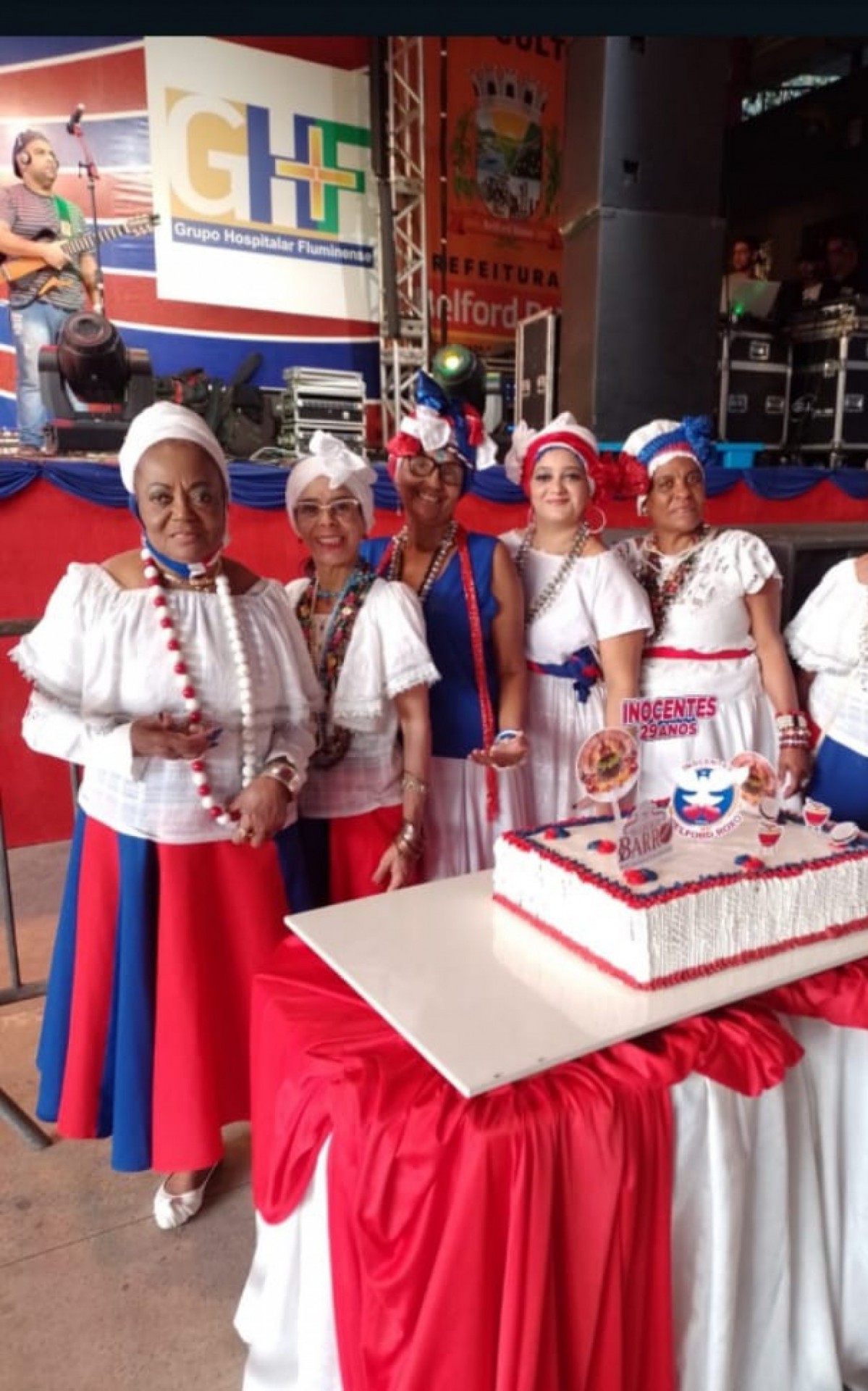 Baianas posando para fotos na mesa do bolo