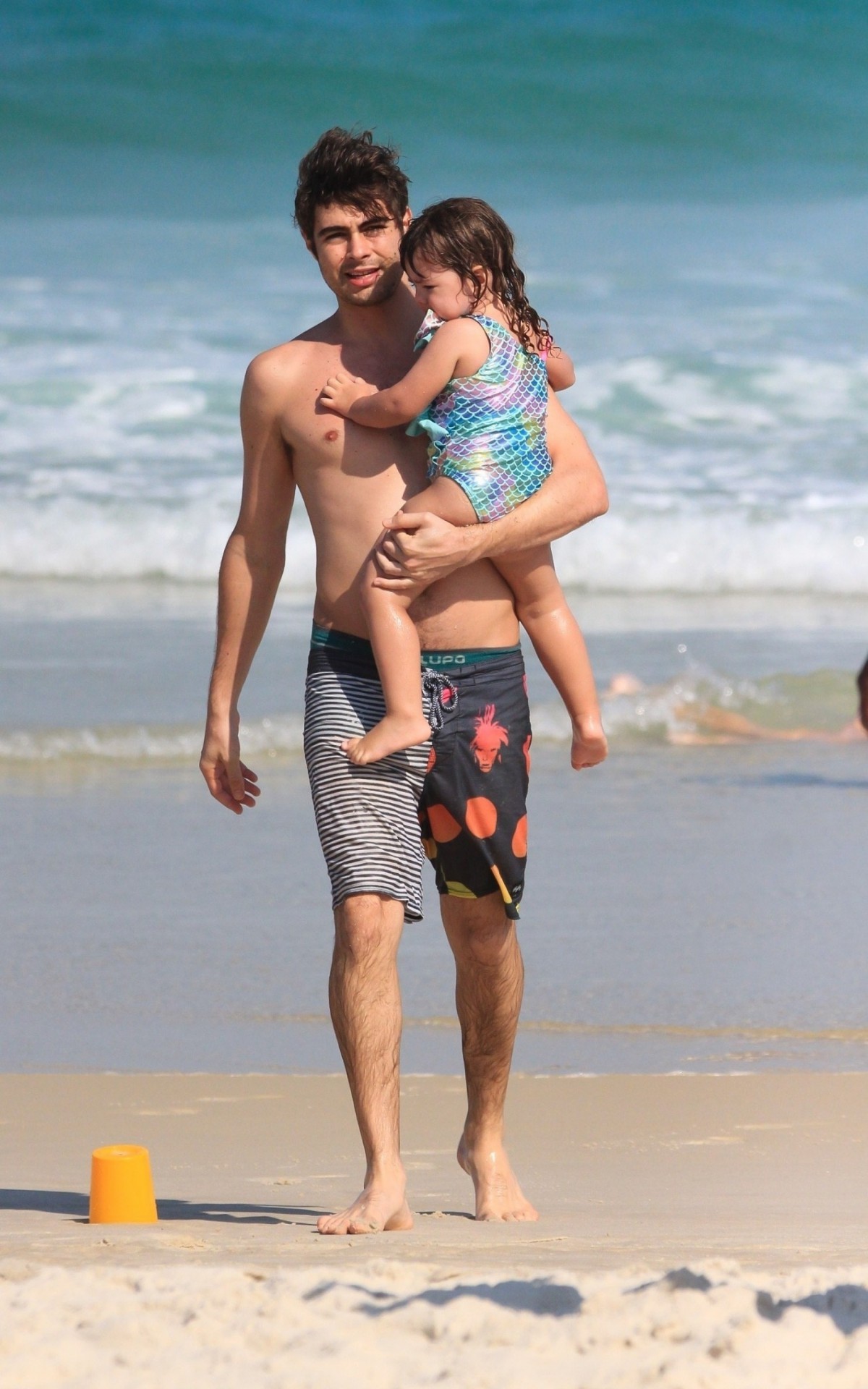 Rafael Vitti caminhou pela areia com Clara Maria no colo depois de curtir banho de mar, nesta segunda-feira