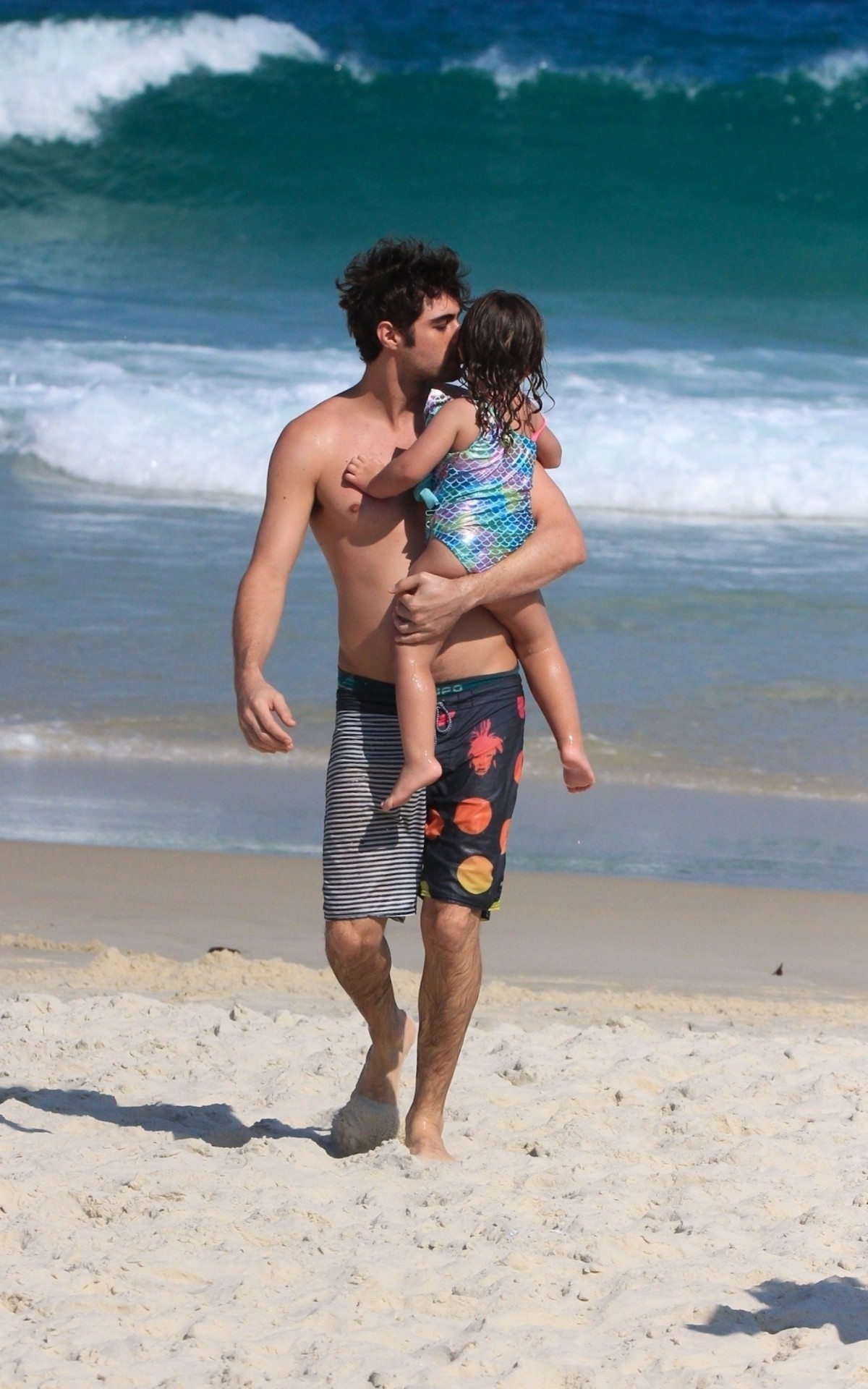 Rafael Vitti caminhou pela areia com Clara Maria no colo depois de curtir banho de mar, nesta segunda-feira