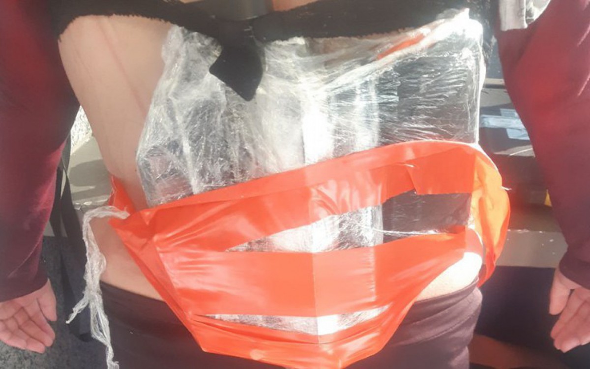 Arma estava presa &Atilde;&nbsp;s costas da mulher encoberta por casaco