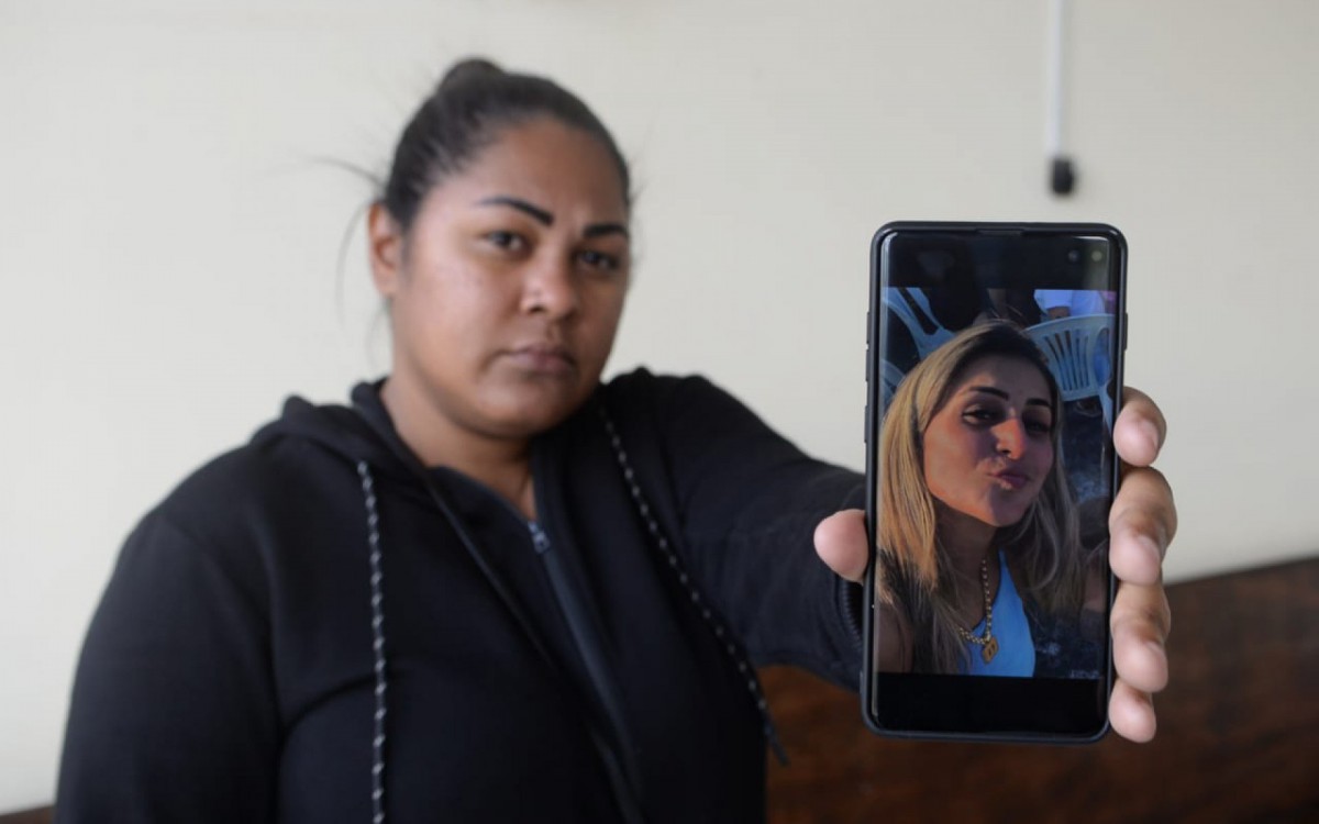 Fab&iacute;ola Oliveira, madrasta de Sabrina, mostra foto da enteada na entrada do IML de Nova Igua&ccedil;u