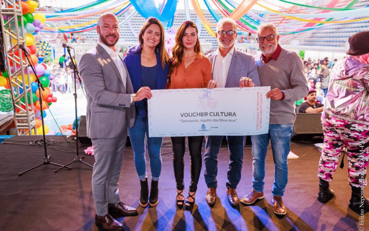 Prefeito Vinicius Claussen, Secret&aacute;ria Municipal de Educa&ccedil;&atilde;o, Satiele Santos, Primeira-dama Paula Sch&uuml;tte Claussen e Vereador Paulinho Nogueira seguram o voucher entregue &agrave;s crian&ccedil;as