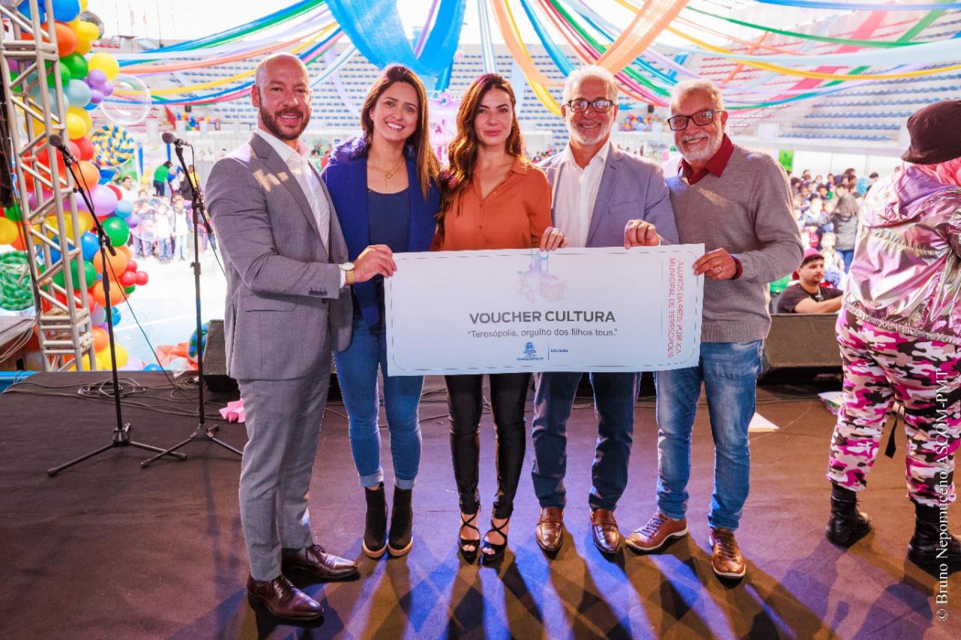 Prefeito Vinicius Claussen, Secret&aacute;ria Municipal de Educa&ccedil;&atilde;o, Satiele Santos, Primeira-dama Paula Sch&uuml;tte Claussen e Vereador Paulinho Nogueira seguram o voucher entregue &agrave;s crian&ccedil;as - Bruno Nepomuceno