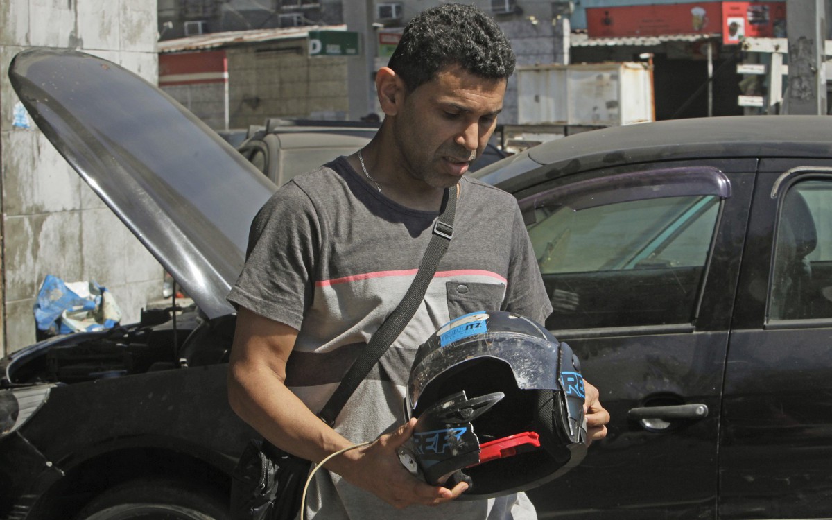 Geral - Acidente com morte na Avenida Brasil, pista sentido centro, na altura do Caju, zona norte do Rio, na manha de hoje. Ariston Diniz, 45 anos, seguia para o trabalho de moto quando foi vitima de um acidente e nao resistiu. Na foto, Francisco de Assis, irmao da vitima, com o capacete do irmao.