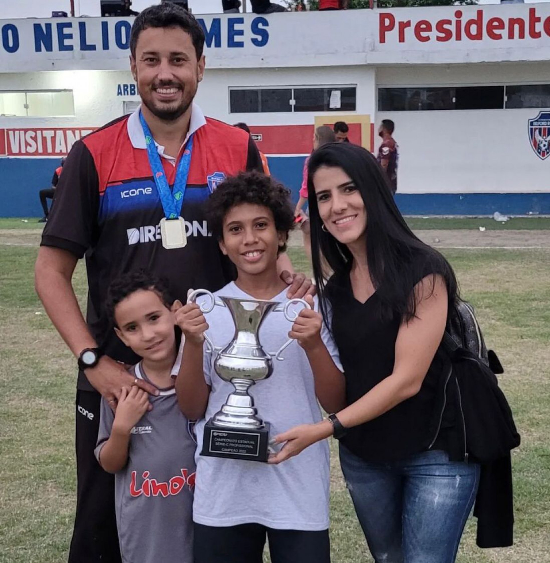 O técnico Diego Brandão, com a esposa Marcela do Nascimento, seu filho Matheus Brandão, seu sobrinho Miguel Henriques, com a taça de campeão da Série C do Estadual - Divulgação