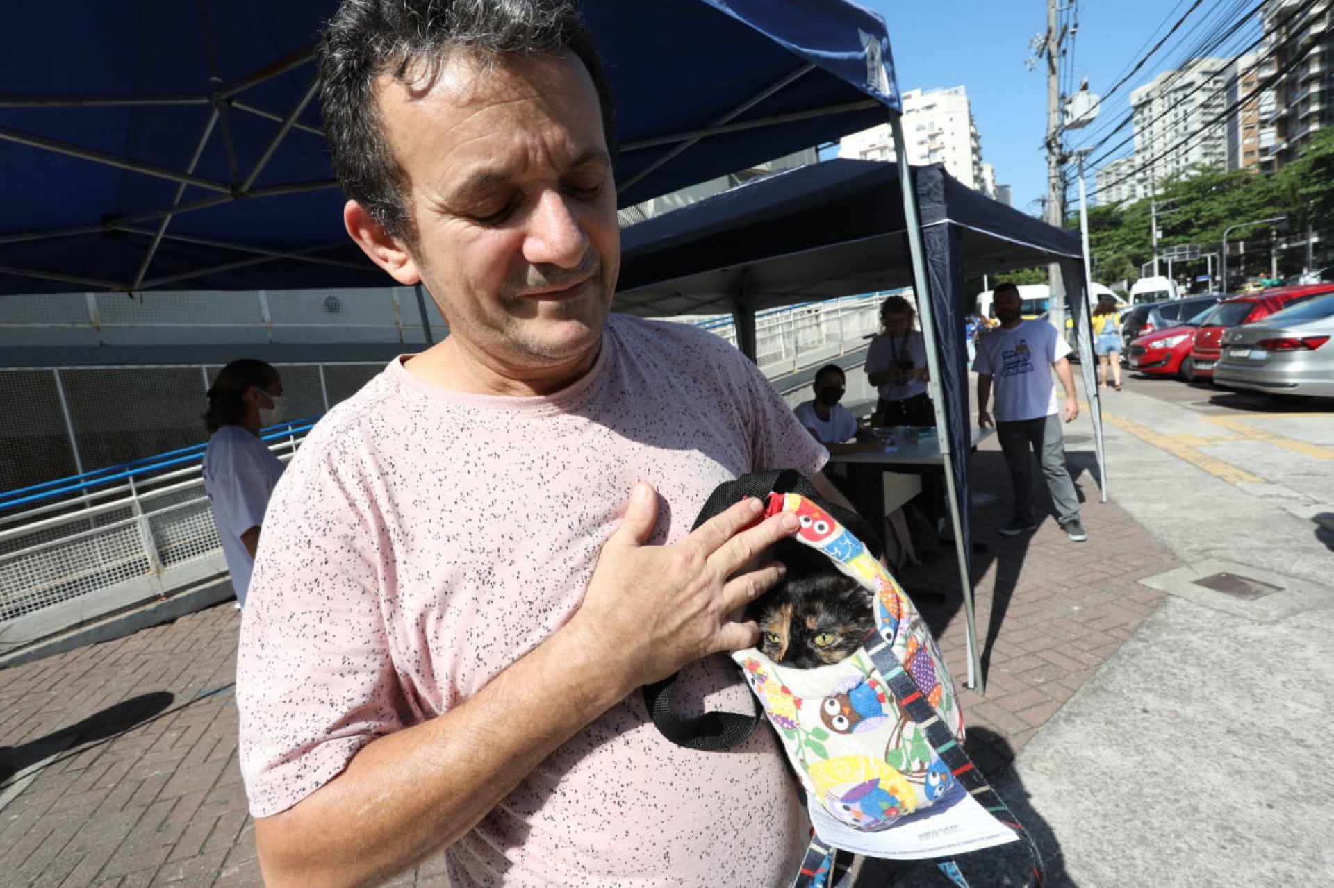 Antônio Carlos Lourenço, de 51 anos, e a gatinha Linda, escondida na bolsa - Pedro Ivo/ Agência O Dia