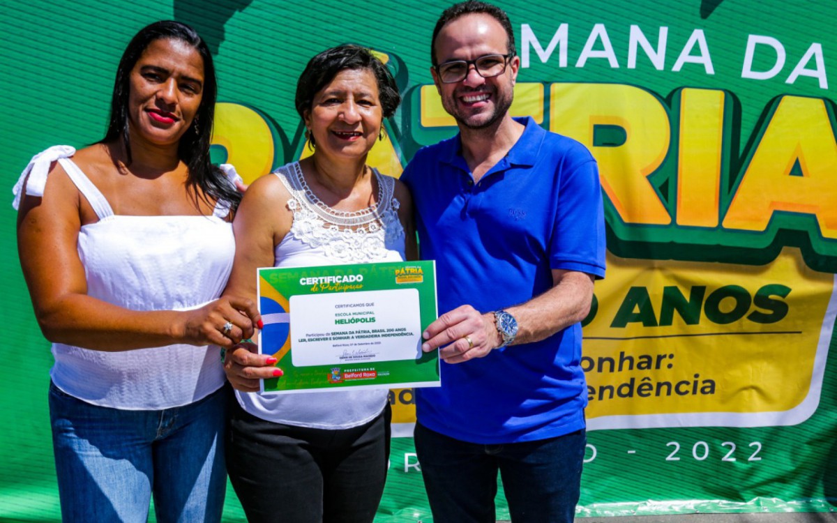 O secret&aacute;rio Denis Macedo entregou o diploma de participa&ccedil;&atilde;o da Escola Municipal Heli&oacute;polis &agrave; orientadora Pedag&oacute;gica Ranyeire Brand&atilde;o