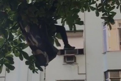 Vídeo: Homem cai de parapente e fica preso em árvore em Copacabana