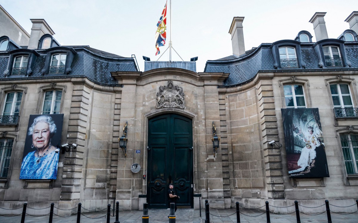 The Union Jack flies at half mast at the main gate of the British embassy in Paris and two portraits of Queen Elisabeth II hang on its walls after the annoucement of her death on September 8, 2022. Queen Elizabeth II, the longest-serving monarch in British history, has died aged 96, Buckingham Palace said on September 8, 2022. Her eldest son, Charles, 73, succeeds as king immediately, according to centuries of protocol, beginning a new, less certain chapter for the royal family after the queen's record-breaking 70-year reign.