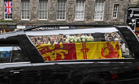 Público assiste ao carro funerário carregando o caixão da rainha Elizabeth II - NEIL HANNA / AFP