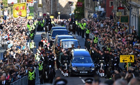 Members of the public gather to watch the procession of Queen Elizabeth II's coffin, from the Palace of Holyroodhouse to St Giles Cathedral, on the Royal Mile on September 12, 2022, where Queen Elizabeth II will lie at rest. Mourners will on Monday get the first opportunity to pay respects before the coffin of Queen Elizabeth II, as it lies in an Edinburgh cathedral where King Charles III will preside over a vigil.
ANDY BUCHANAN / AFP - AFP