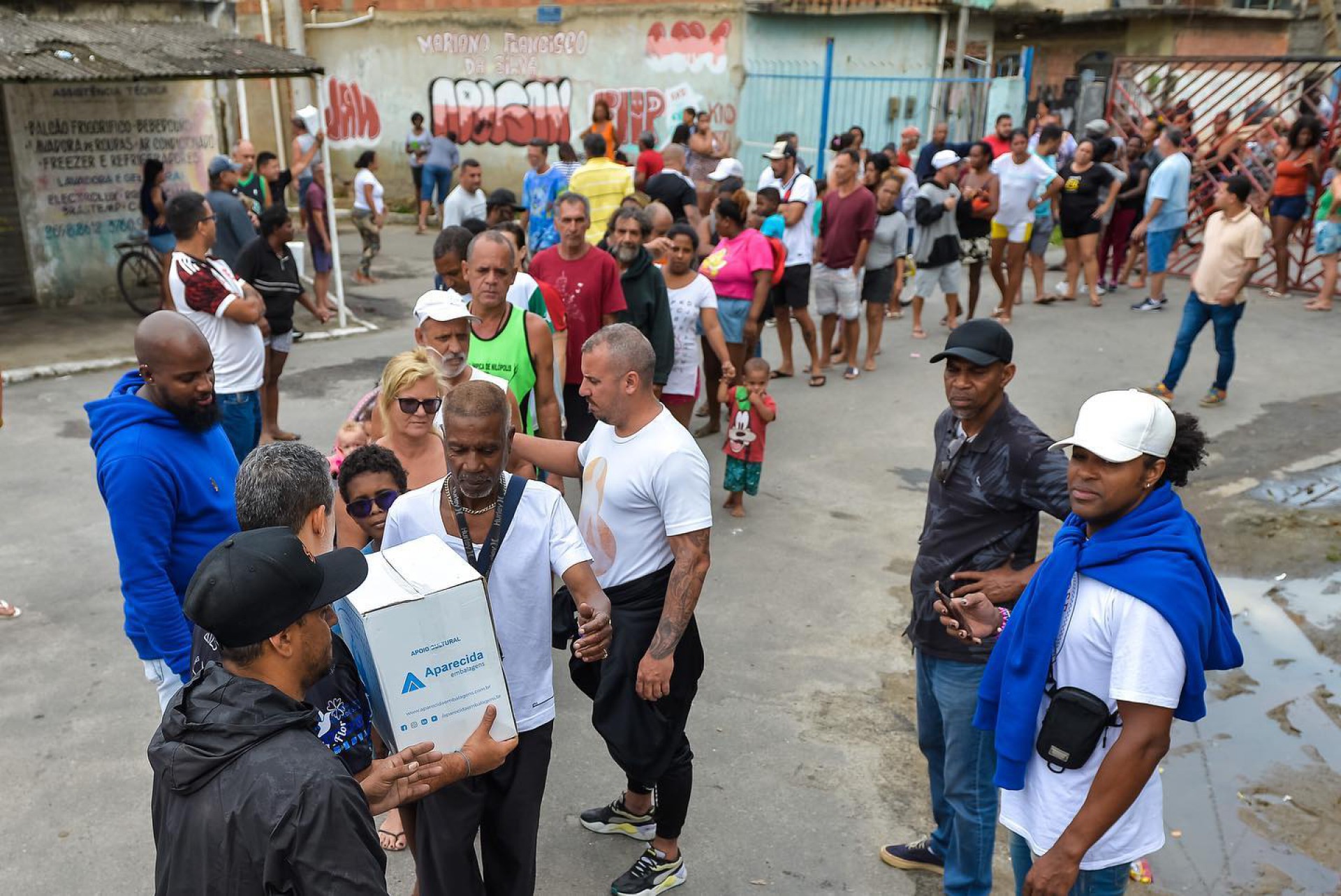 Uma fila se formou para o recebimento da tradicional entrega de cestas b&aacute;sicas da Beija-Flor de Nil&oacute;polis - Divulga&ccedil;&atilde;o