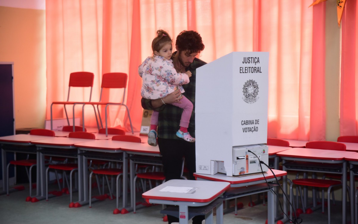 Chay Suede votou com a filha, Maria, no colo