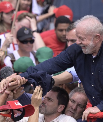 Brazilian former President (2003-2010) and presidential candidate for the leftist Workers Party (PT) Luiz Inacio Lula da Silva (R) greets supporters during a campaign rally between Belo Horizonte and Ribeirao das Neves, Minas Gerais state, Brazil, on October 22, 2022. Veteran leftist Luiz Inacio Lula da Silva said he is keeping an eye on poll numbers showing his lead narrowing over far-right incumbent Jair Bolsonaro for Brazil's October 30 presidential runoff but is confident he will win.
DOUGLAS MAGNO / AFP
