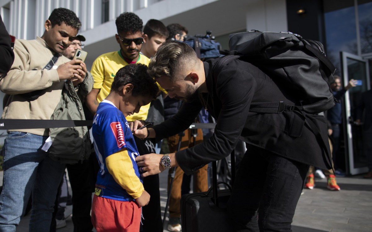 Everton Ribeiro d&aacute; aut&oacute;grafo a torcedor italiano