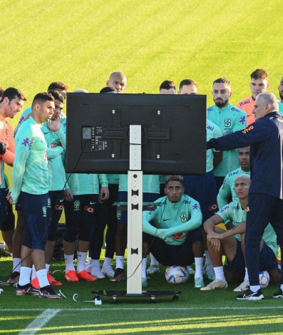 Brazil's coach Tite (Front R) gathers players and staff around a television screen during a training session on November 16, 2022 at the Continassa training ground in Turin, as part of Brazil's preparation ahead of the Qatar 2022 World Cup.