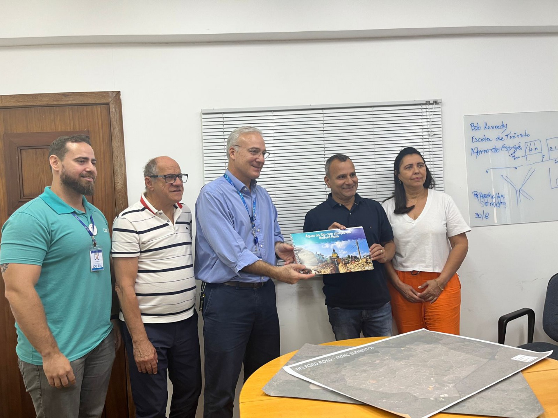 O prefeito Waguinho (camisa preta) recebendo das mãos do diretor-superintendente Luiz Fabbriani, o balanço das ações da Águas do Rio no município - Divulgação