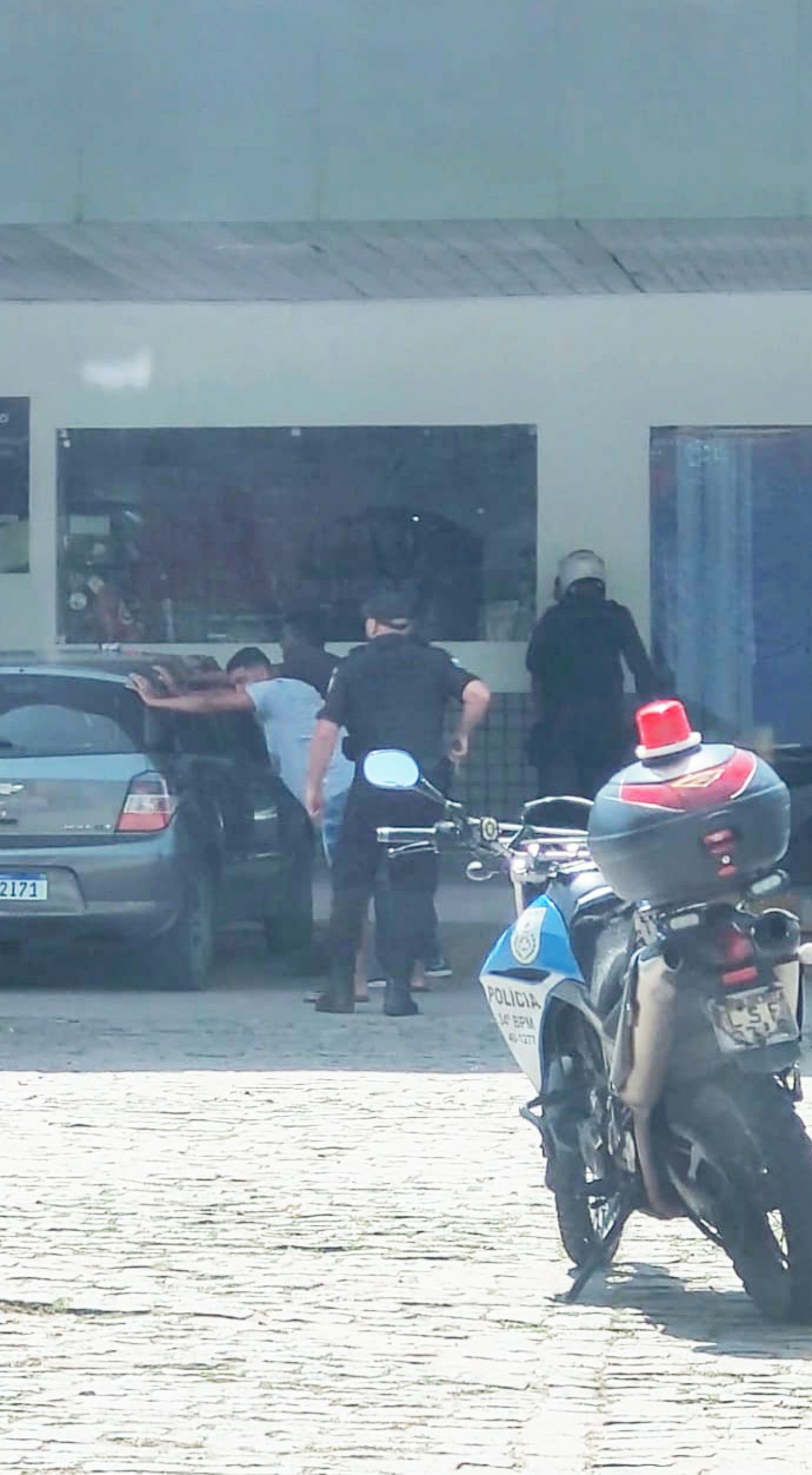 Momento em que os bandidos s&atilde;o revistados num posto de gasolina, em Guapimirim