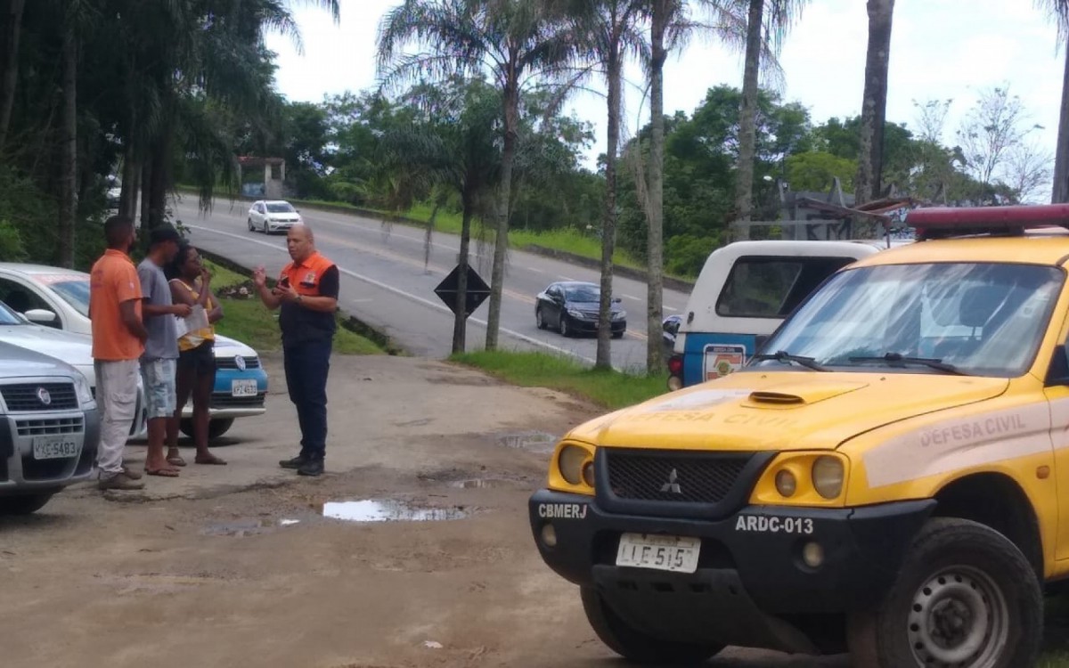 Agente de Defesa Civil do Estado orientando moradores de &aacute;rea de risco.