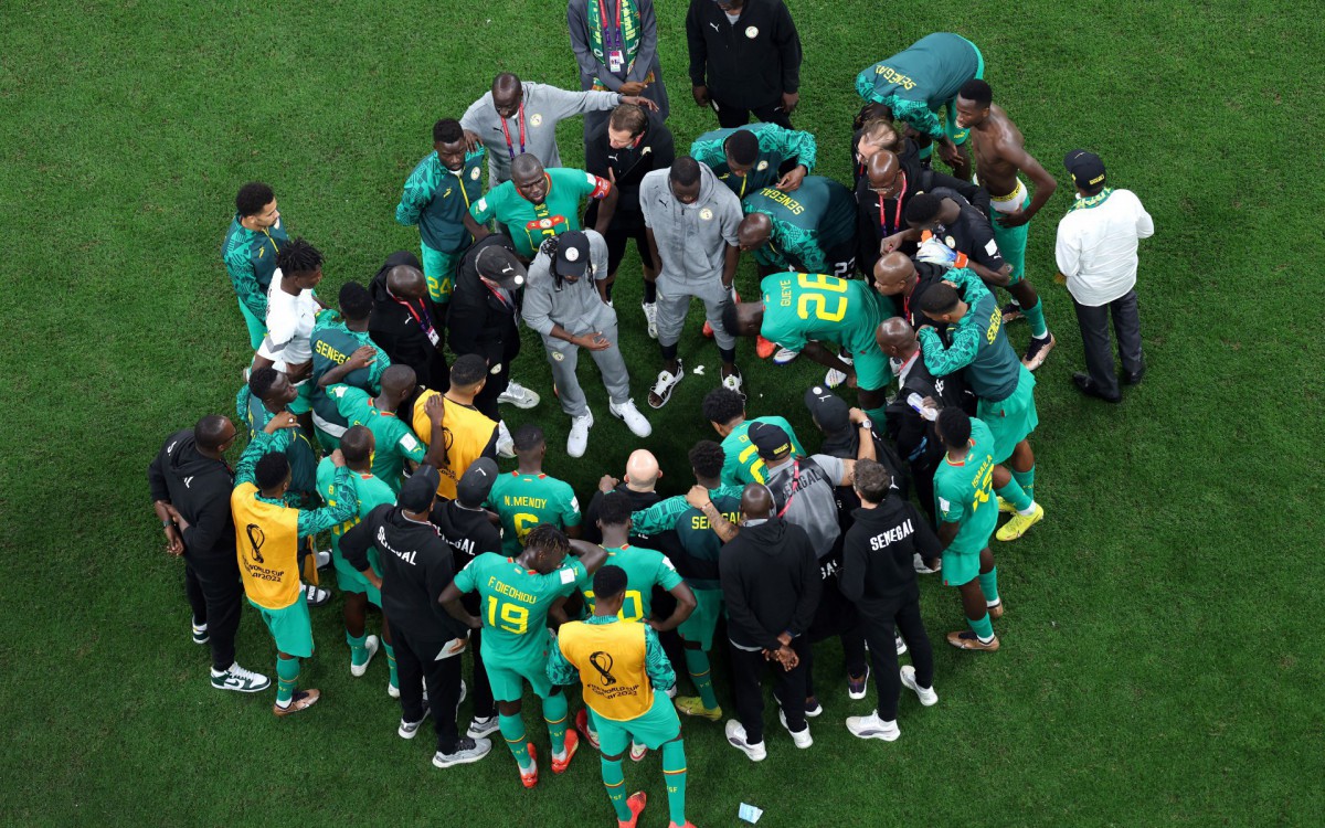 Comiss&atilde;o t&eacute;cnica e jogadores de Senegal reunidos no gramado ap&oacute;s a elimina&ccedil;&atilde;o da Copa do Mundo do Catar 