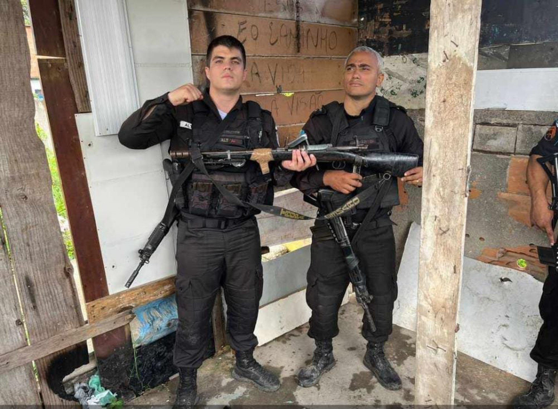 Os policiais militares com o fuzil apreendido - Twitter / Pmerj