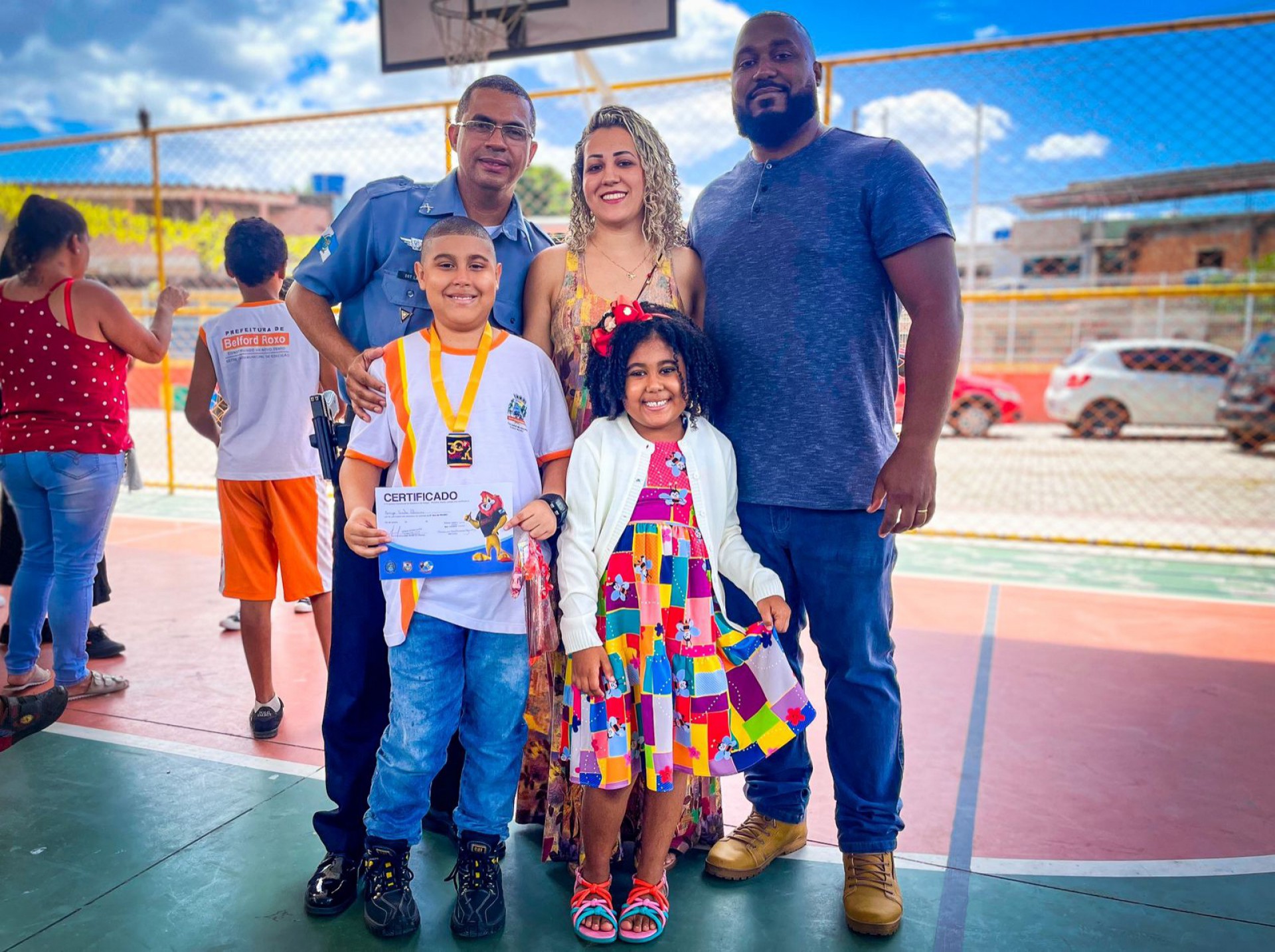 O pai Alexandre Oliveira, a m&atilde;e Sara e a irm&atilde; Ellen orgulhosos, ao lado do sargento Lacerda, na formatura de Enzo &Aacute;vila - Matheus Breda / PMBR