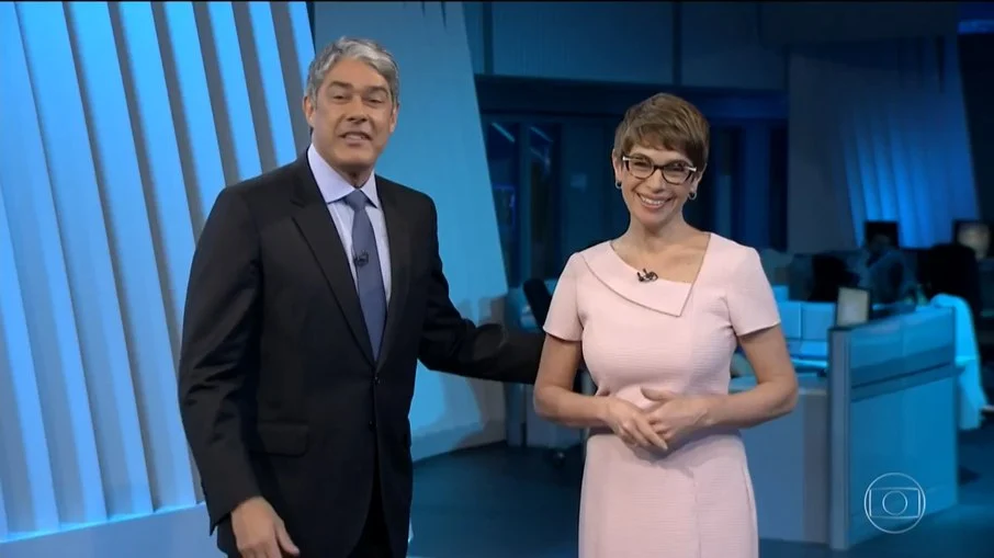 Bonner faz piada com tênis de Renata Lo Prete, que cai na gargalhada