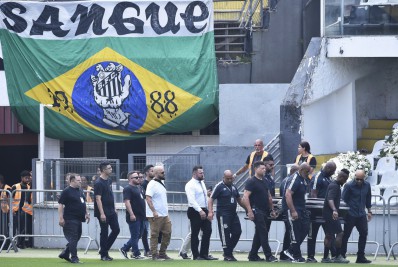Carregado por filho, caixão de Pelé é colocado no centro do gramado da Vila Belmiro