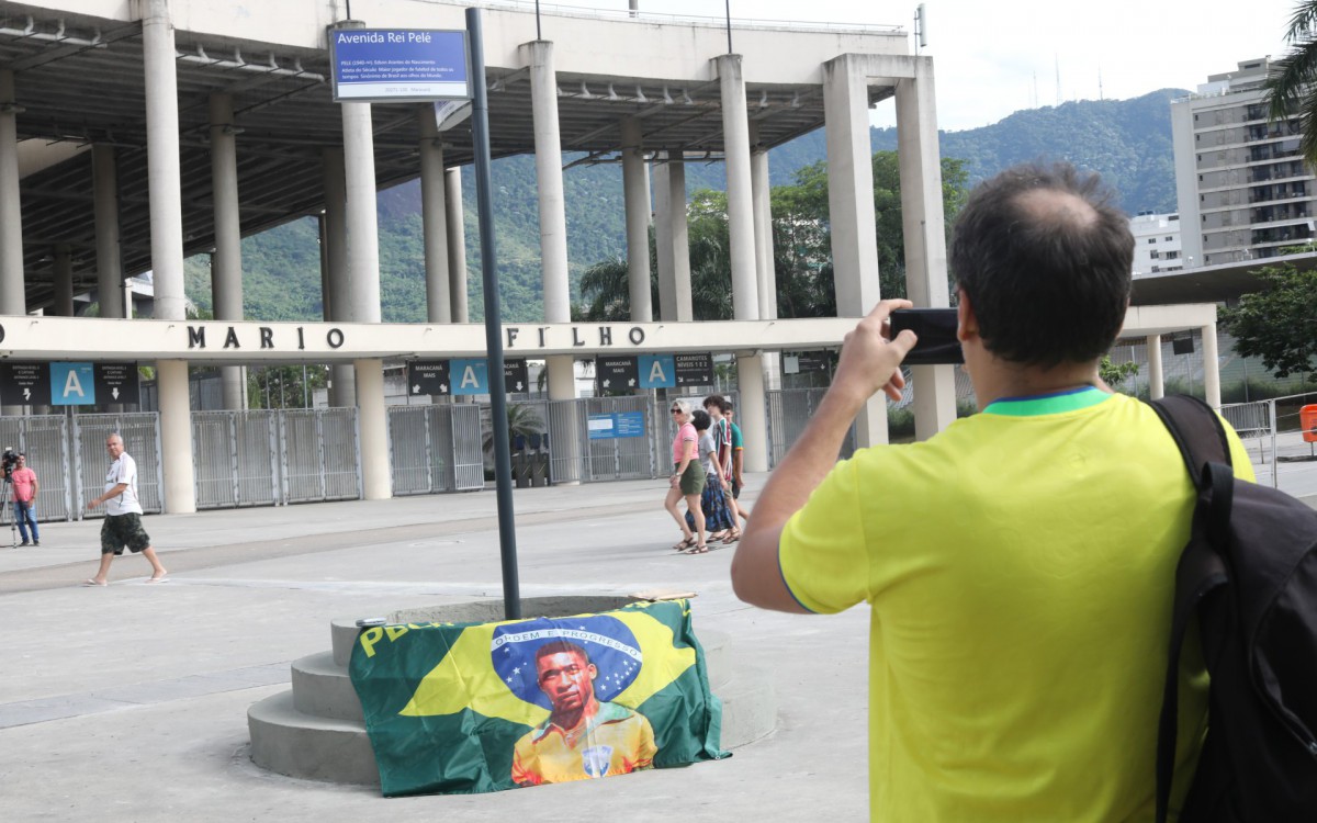Parte da Av. Radial Oeste em frente ao Maracan&atilde; recebeu o nome de Av. Rei Pel&eacute;. Na foto,  Felipe Ferreira, torcedor e f&atilde; do Pel&eacute;, trouxe uma bandeira e tirou fotos na nova placa.