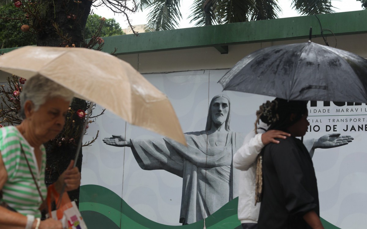   Dias de chuva na cidade do Rio de Janeiro.  Na fotos: pedestres caminham pelo Largo do Machado com guarda chuvas e capas. - Pedro Ivo