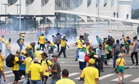 Supporters of Brazilian former President Jair Bolsonaro clash with the police during a demonstration outside the Planalto Palace in Brasilia on January 8, 2023. Brazilian police used tear gas Sunday to repel hundreds of supporters of far-right ex-president Jair Bolsonaro after they stormed onto Congress grounds one week after President Luis Inacio Lula da Silva's inauguration, an AFP photographer witnessed.
 - EVARISTO SA / AFP