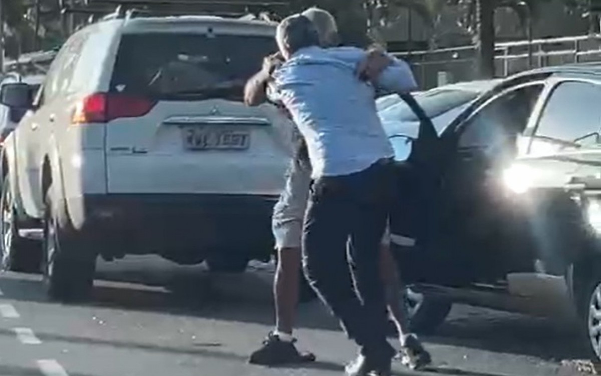 O policial militar da reserva sai do carro segurando bast&atilde;o para brigar com outro motorista, com quem teve desentendimento