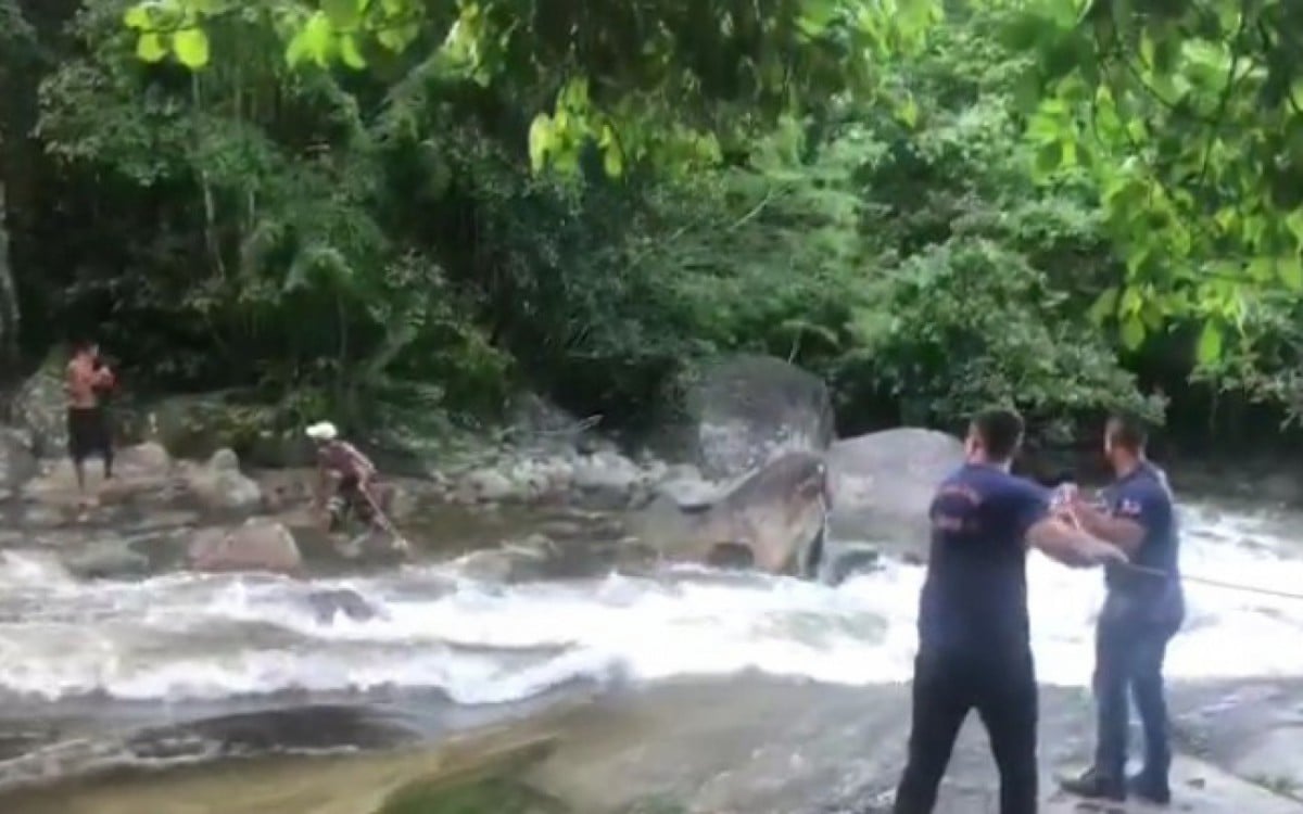 Momento em que os agentes da Defesa Civil de Guapimirim lançam uma corda para os adolescentes atravessarem o rio - SSEOP Guapimirim - Imagem cedida ao DIA