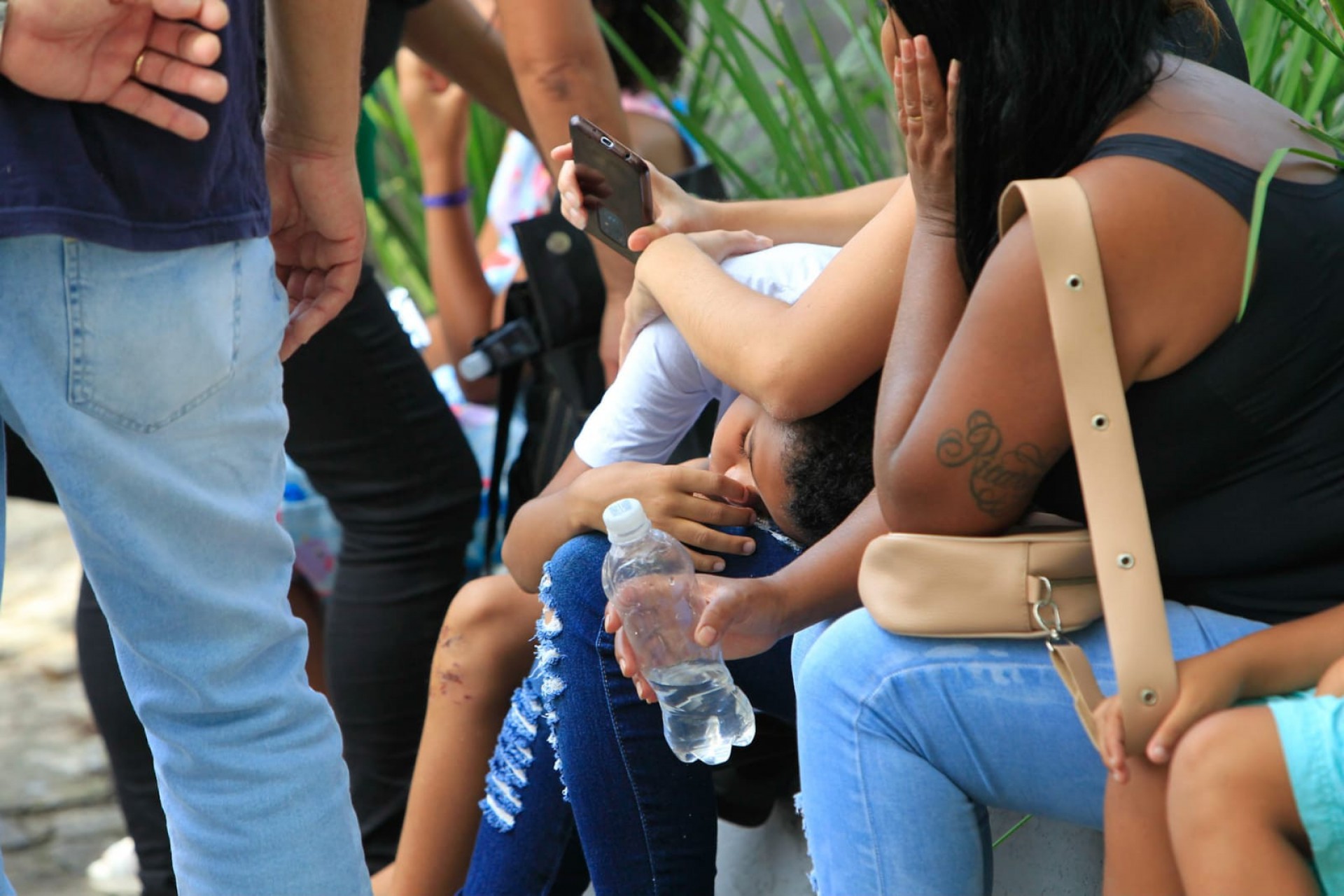 Filho de Juliana Gomes de Lana da Silva que sobreviveu ao naufrágio é consolado por parentes durante sepultamento - Reginaldo Pimenta/Agência O Dia