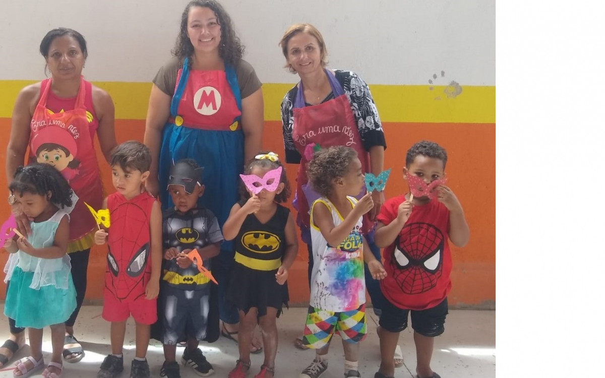A professora Mariana Ramalho (ao centro) com as estimuladoras Dalila e Elaine no bailinho com as crian&ccedil;as