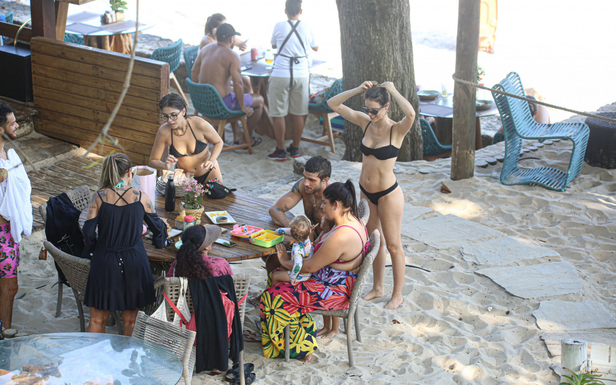 Chay Suede e Laura Neiva com os filhos na praia de Grumari 