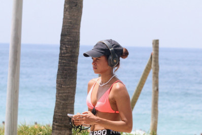 De top rosa, Lucy Alves se exercita na orla da Zona Sul